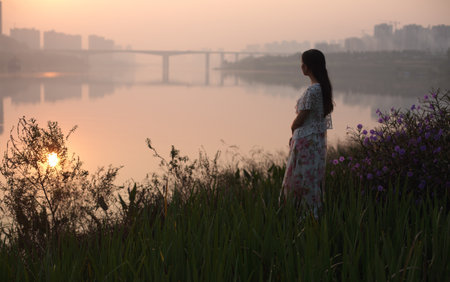 Gazing at the sunrise over the riverの写真素材