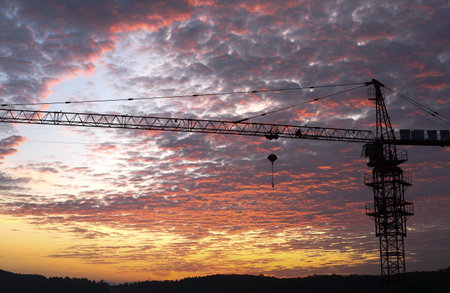 Construction site with cranes at sunset. Colorful sky with clouds.の写真素材