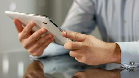 Businessman working on tablet PC, using mobile app, technology in business
