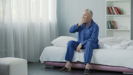 Man in his 50s with joy and cheerfulness meeting new day yawning, good morningの写真素材