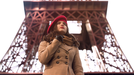 Concerned young lady standing near Eiffel Tower alone, waiting for friendの写真素材