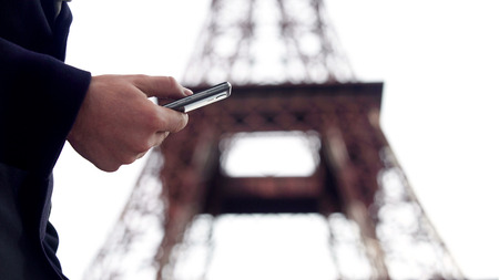 Man surfing internet on smartphone, booking tickets and hotel for business tripの写真素材