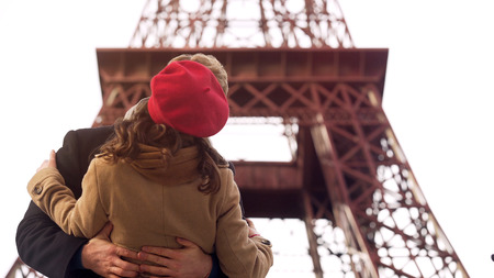 Enamored man passionately kissing beloved woman on romantic date in Parisの写真素材