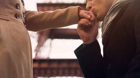 Man confessing his feelings and kissing hand to his girlfriend, standing on kneeの写真素材
