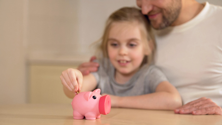 Father teaching little daughter to save money in piggy bank, financial literacy, stock footageの写真素材
