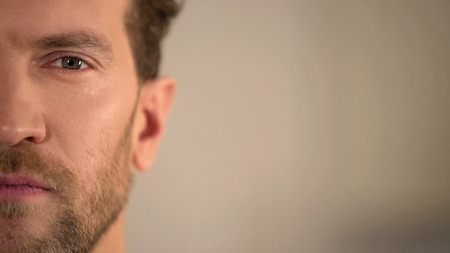 Young male half face looking into camera, average man opinion poll, statistics, stock footageの写真素材