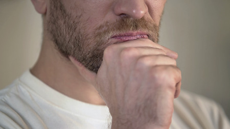 Serious adult man with beard rubbing chin, having doubts, thinking, close-up, stock footageの写真素材