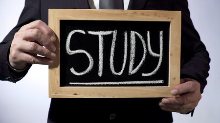 Study written on blackboard, businessman holding sign, career and future, stock footage