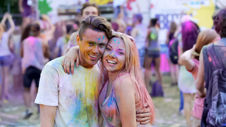 Happy friends hanging out at festival, romantic couple hugging, enjoying partyの写真素材