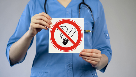 Nurse holding in hands no smoking card, harmful habit, medicine and healthcareの写真素材
