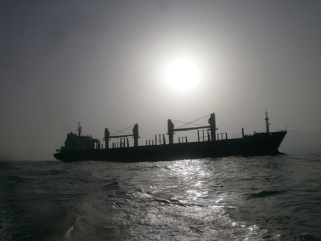 Cargo ship at sunset foggy weatherの写真素材