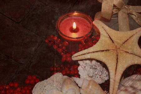 red candle lit background, red berries, shells, starfishの写真素材