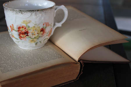 antigue tea cup on old book の写真素材