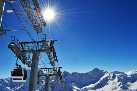 the cabin of the ski lift rises to the peak of the mountains.の写真素材