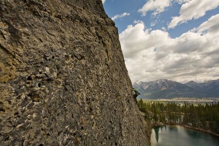 Rock climber high above lake in the Canadian Rockiesの写真素材