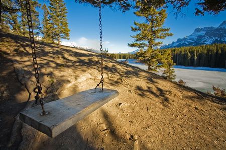 Swing on edge of frozen mountain lakeの写真素材