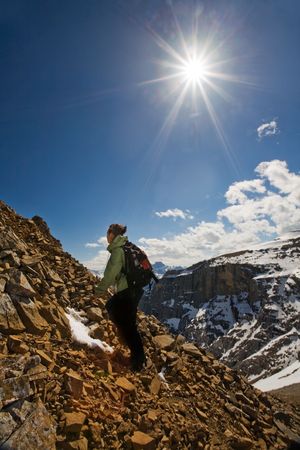 Young female hiker approaching summit of snowy peak in the Canadian Rocky Mountainsの写真素材