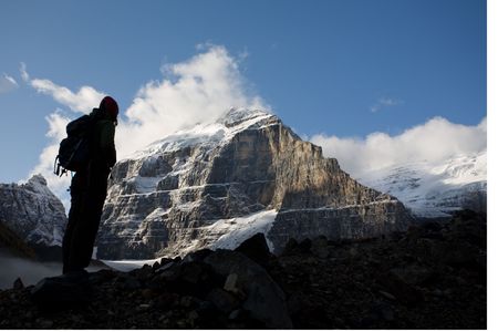 Silhouette of woman standing beneath high peak of the Rocky Mountains, Banff National Park, Alberta,...