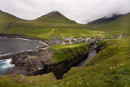 Small oceanside village surrounded by green hills, Gjgv, Faroe Islands, Scandinaviaの写真素材