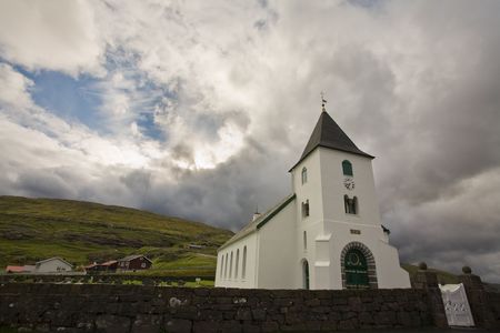 White church towers above small village, Faroe Islands, Scandinaviaの写真素材
