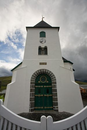 White church towers above small village, Faroe Islands, Scandinaviaの写真素材