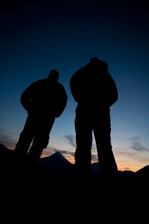Silhouette of two women watching sunset in the Rocky Mountains, Kananaskis Country, Alberta, Canada.の写真素材