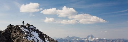 Climber reaches snowy summit in the Rocky Mountains, Kananaskis Country, Alberta, Canada.