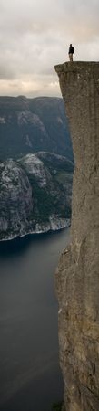 Silhouette of preson standing at the edge of immense cliff, high above the water, Lysefjord, Norway, Scandinaviaの写真素材