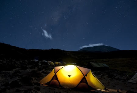 Kikelelwa Cave campsite on Rongai Route at night with Kilimanjaro shrouded in clouds under the stars and milky wayの写真素材