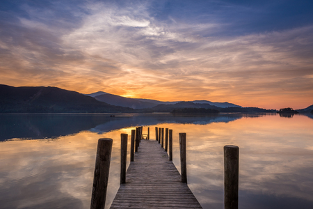 The sun setting over a calm Derwent Water in Lake Districtの写真素材
