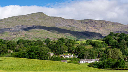 Coniston village and The Old Man of Coniston with its many slate mines and workings on its slopes during early summer in the Lake Districtの写真素材