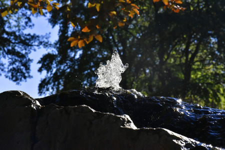 Water fountain in park, the water is flowing on a rock.の写真素材