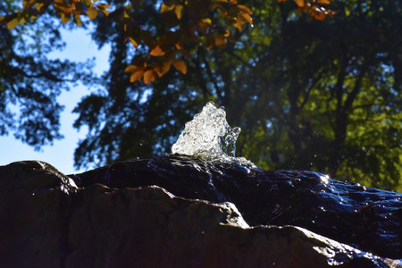 Water fountain in park, the water is flowing on a rock.の写真素材