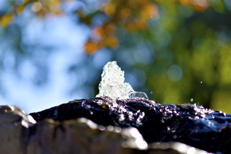 Water fountain in park, the water is flowing on a rock.の写真素材