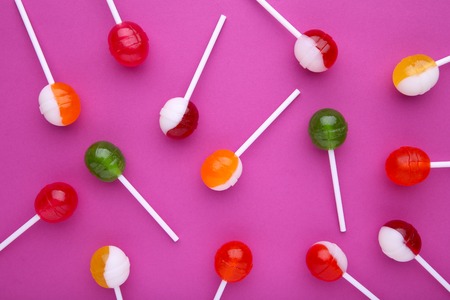 Sweet colorful lollipop on pink background