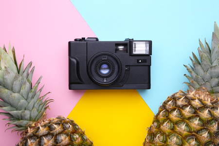 Ripe pineapples with camera on a colorful backgroundの写真素材