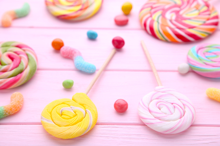 Colorful lollipops and different colored round candy on pink backgroundの写真素材
