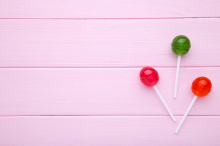 Red and green lollipops on pink wooden background. sweet candy conceptの写真素材