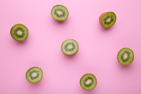 Fresh kiwi fruit on pink wooden background, flat layの写真素材