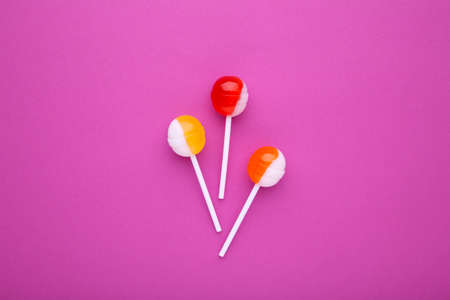 Sweet colorful lollipops on pink background