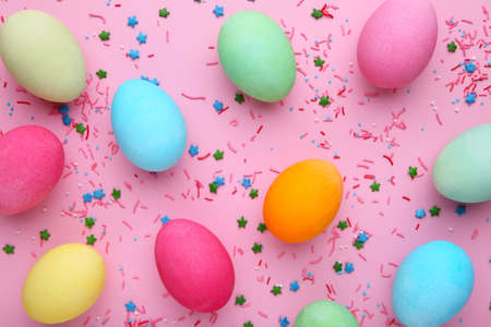 Colorful easter eggs with sprikles on a pink background, flat layの写真素材