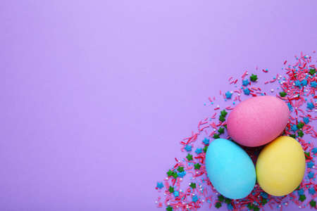 Colorful easter eggs with sprikles on a pink background, flat lay