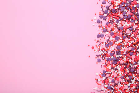 Colorful sprinkles on a pink background, top view with copy spaceの写真素材