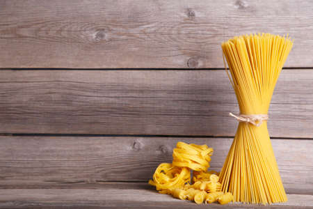 Delicious mixed pasta on gray wooden background with copy spaceの写真素材