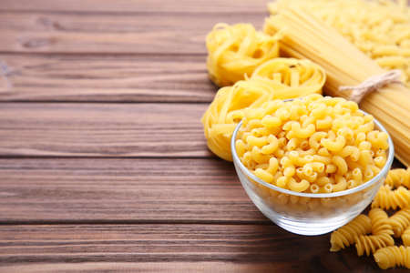 Delicious mixed pasta on brown wooden background with copy spaceの写真素材
