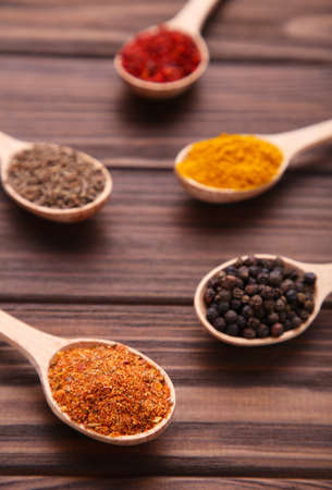 Spices mix on wooden spoons on brown background.の写真素材
