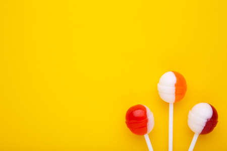 Colorful lollipops on yellow background. sweet candy concept