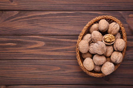 Walnuts kernels in basket on brown wooden background. Walnuts kernels on gray wooden tableの写真素材