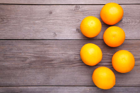Ripe orange fruit on a gray wooden background. Orange on a rustic tableの写真素材