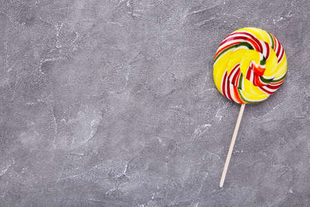 Colorful lollipop on gray concrete background. Studio shotの写真素材